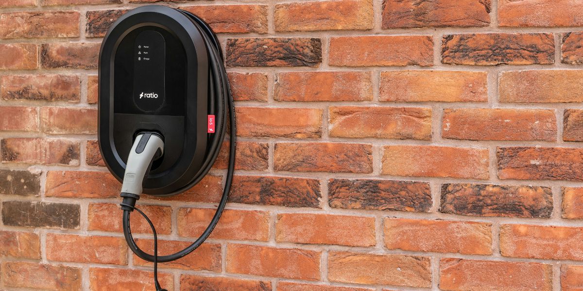 Level 2 EV charger mounted on garage wall showing charging cable and display
